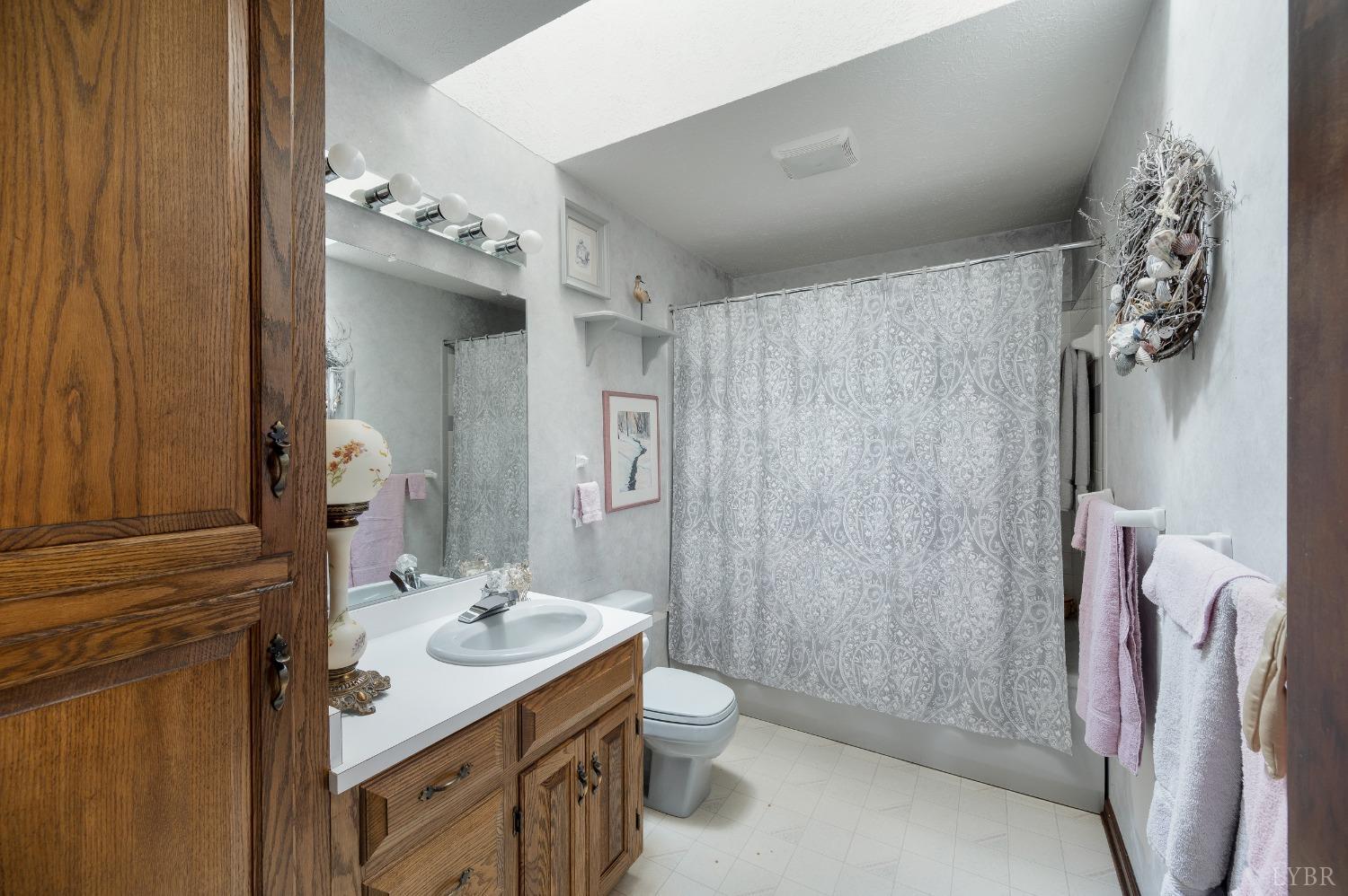 7903 Charlemont Road Goode, VA 24556 - Photo 23 of 47 a bathroom with a double vanity sink mirror and shower