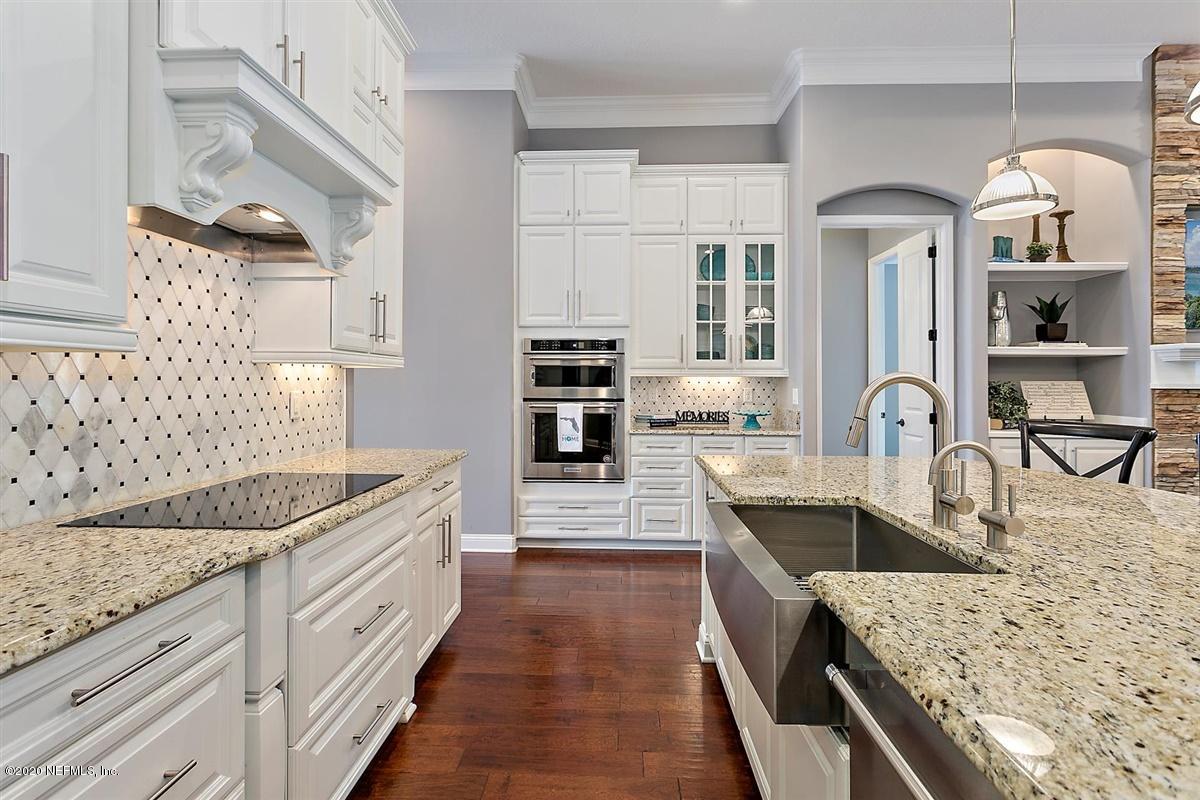 504 Saddlestone Drive St. Johns, FL 32259 - Photo 11 of 42 a kitchen with granite countertop a sink stove and cabinets
