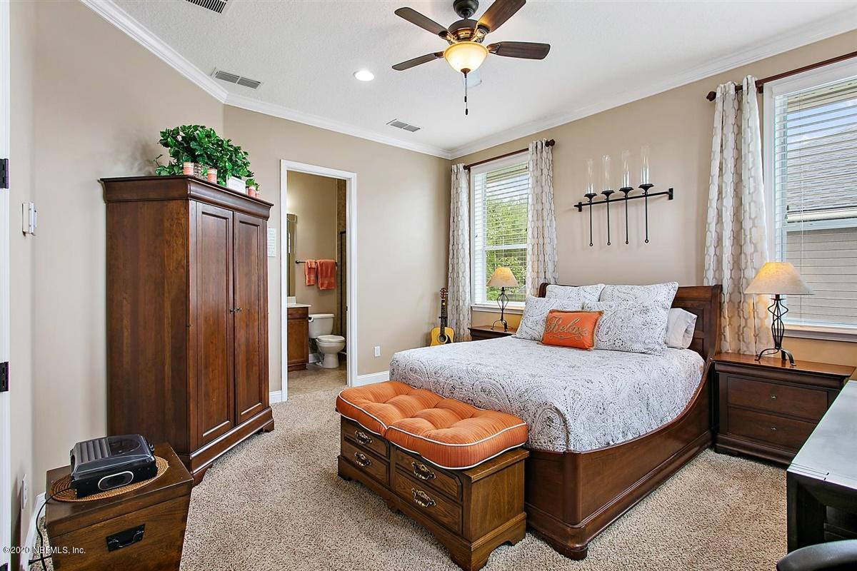 504 Saddlestone Drive St. Johns, FL 32259 - Photo 25 of 42 a bedroom with a bed and a chandelier