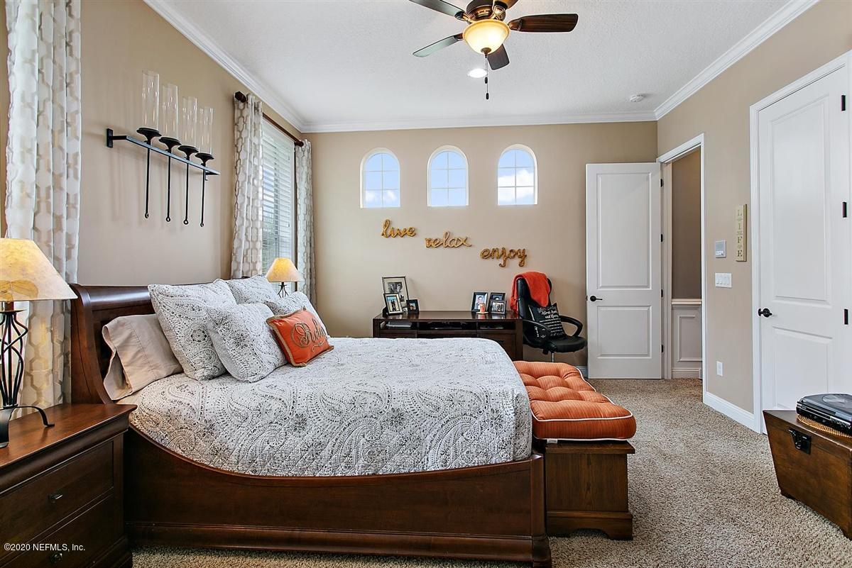504 Saddlestone Drive St. Johns, FL 32259 - Photo 26 of 42 a bedroom with a bed and a chandelier