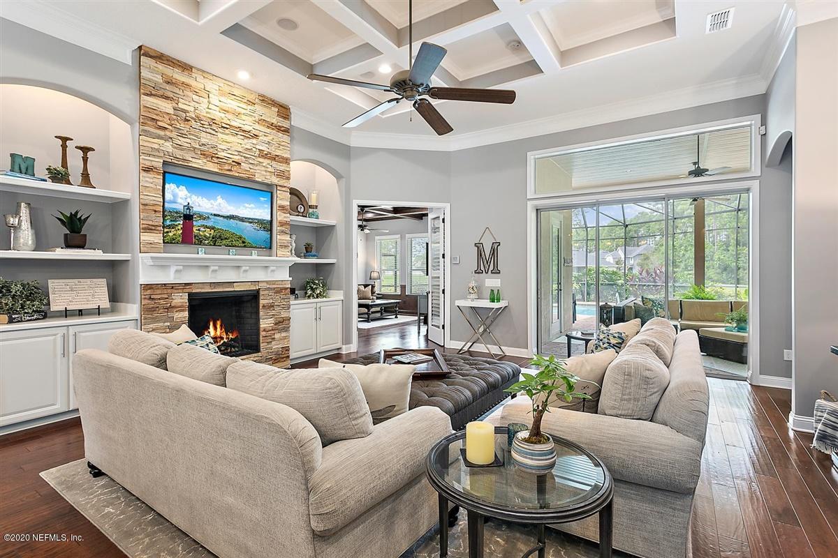 504 Saddlestone Drive St. Johns, FL 32259 - Photo 8 of 42 a living room with furniture a fireplace and a large window