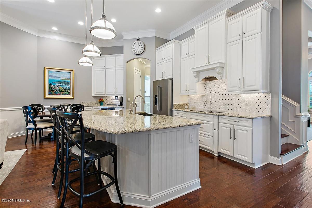504 Saddlestone Drive St. Johns, FL 32259 - Photo 10 of 42 a kitchen with center island table and chairs in it
