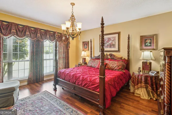 a spacious bedroom with a bed dresser and a window