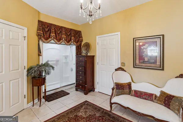 a bedroom with a large bed and a chandelier