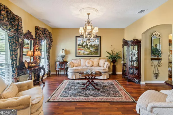 a living room with furniture a dining table and a chandelier