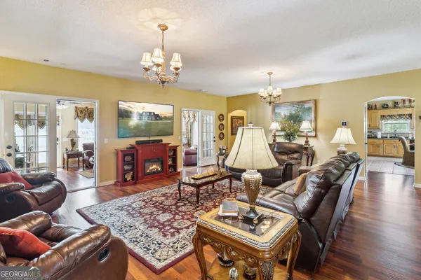 a living room with furniture a chandelier and a rug