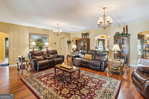 a living room with fireplace furniture and a chandelier