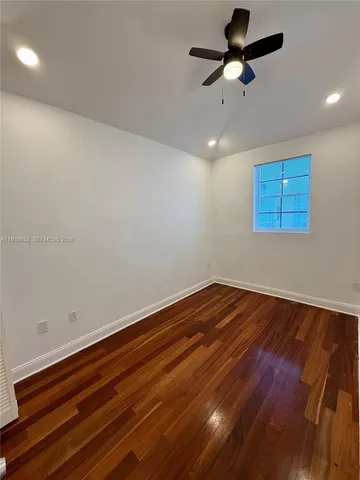 a view of room with hardwood floor and ceiling fan