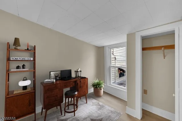 a view of a workspace with furniture and a window