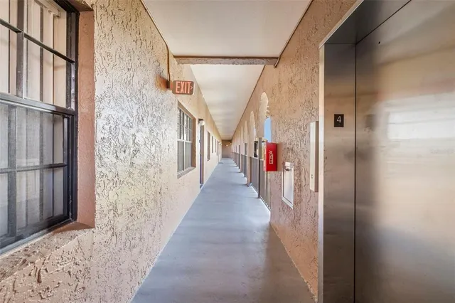 a view of a building with a swimming pool and sitting area