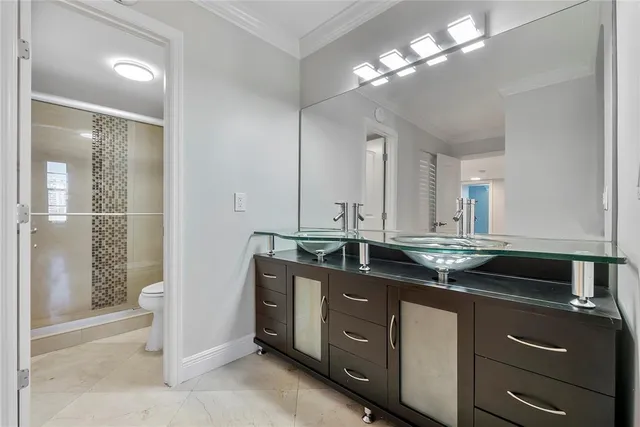 a bathroom with a sink a toilet a mirror and shower