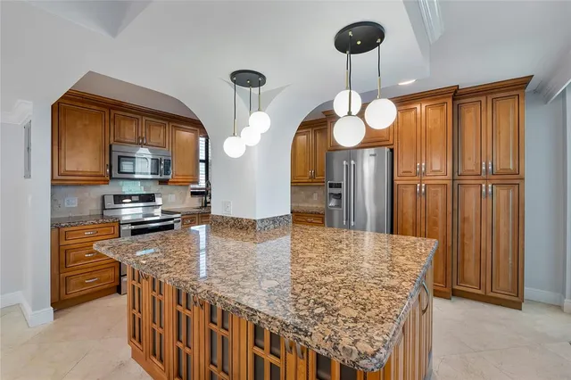 a kitchen with stainless steel appliances granite countertop a stove microwave and cabinets
