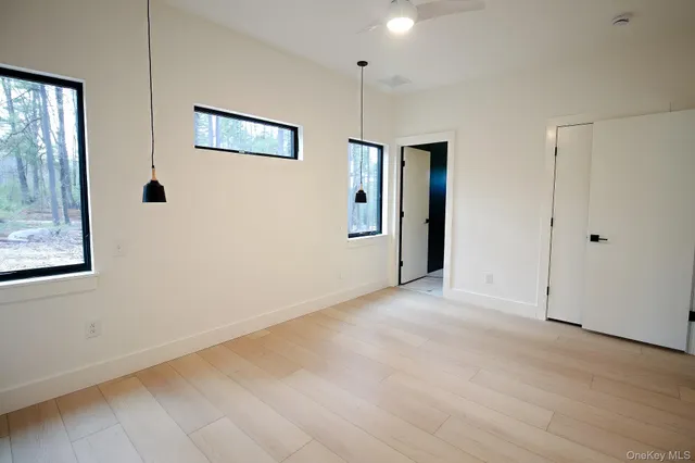 a view of a big room with wooden floor and windows