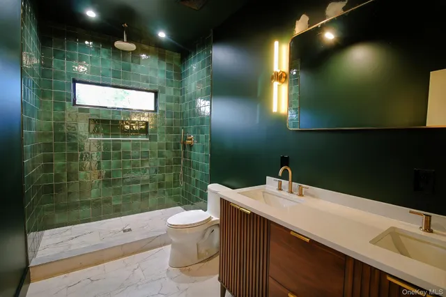 a bathroom with a sink a toilet a mirror and shower