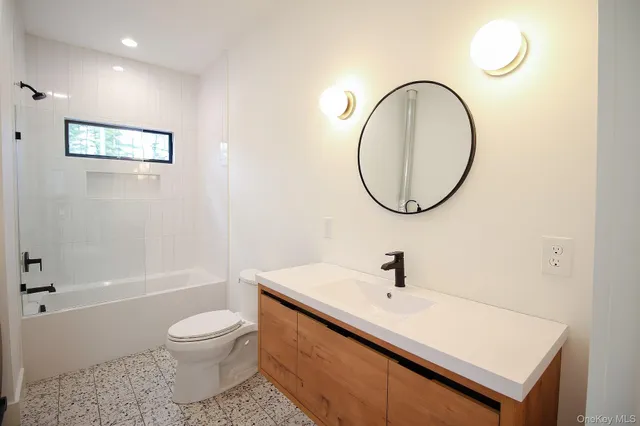 a bathroom with a sink a toilet and a mirror