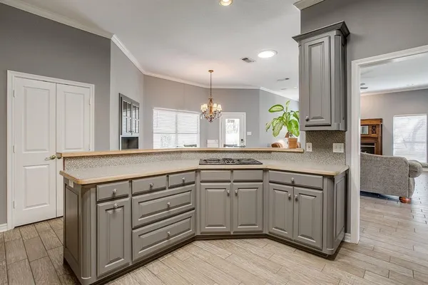 a kitchen with granite countertop a stove cabinets and wooden floor