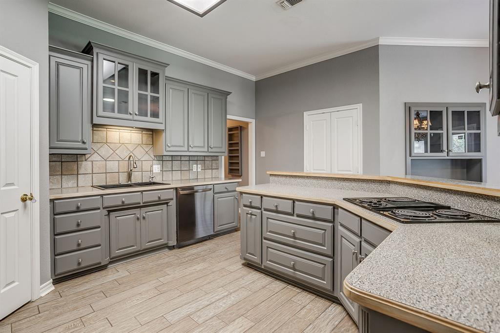 2300 Walter Smith Road Azle, TX 76020 - Photo 16 of 40 a kitchen with granite countertop a stove sink and cabinets