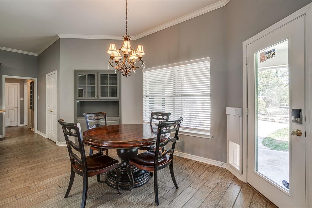 2300 Walter Smith Road Azle, TX 76020 - Photo 17 of 40 a dining room with furniture a chandelier and wooden floor