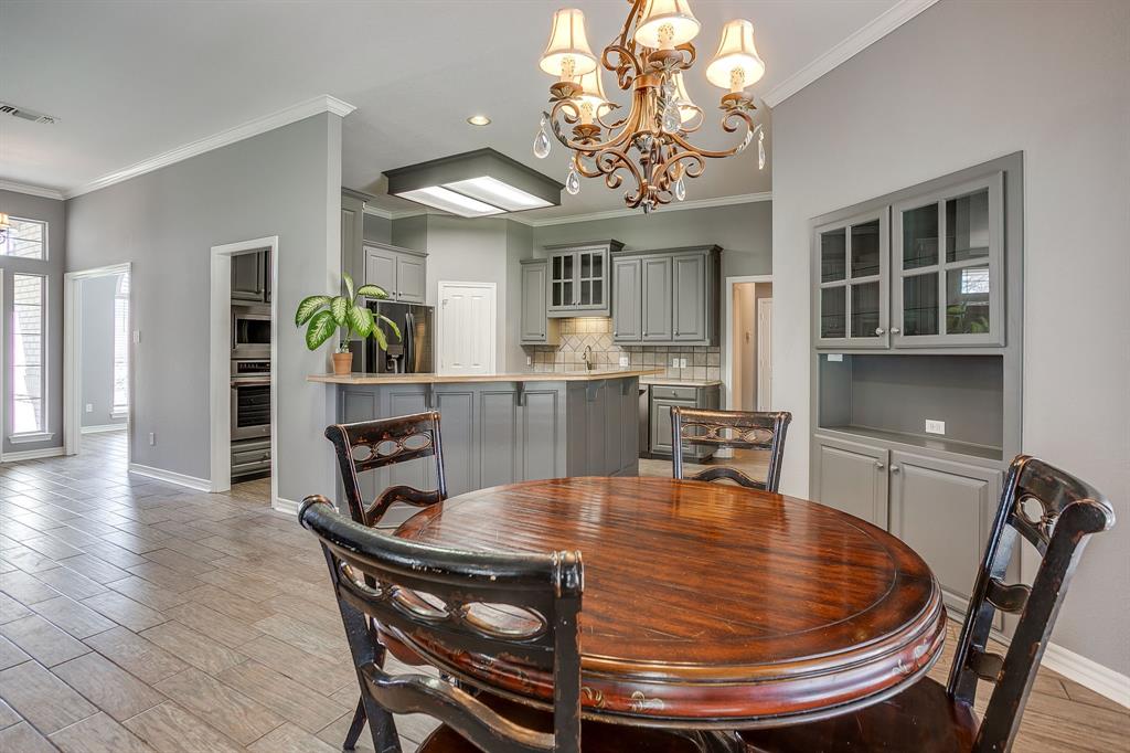 2300 Walter Smith Road Azle, TX 76020 - Photo 18 of 40 a dining room with wooden floor a chandelier a wooden table and chairs