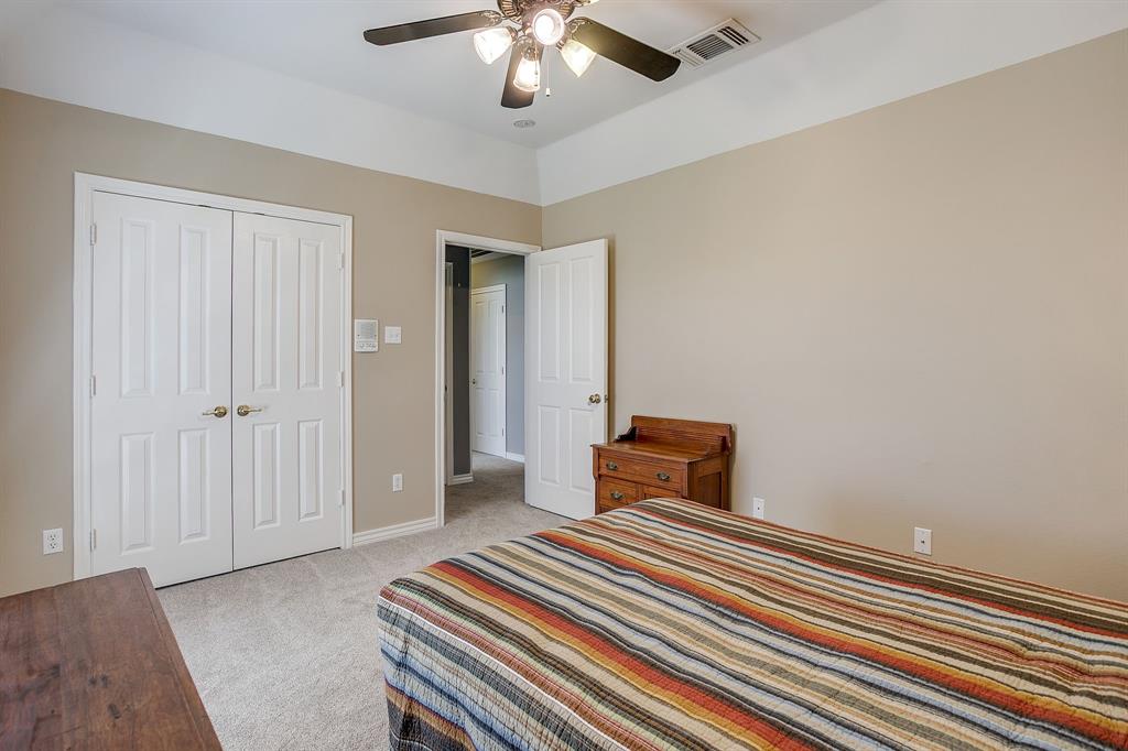 2300 Walter Smith Road Azle, TX 76020 - Photo 19 of 40 a bedroom with a bed and a chandelier