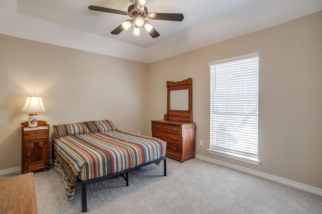 2300 Walter Smith Road Azle, TX 76020 - Photo 20 of 40 a bedroom with a bed and a chandelier
