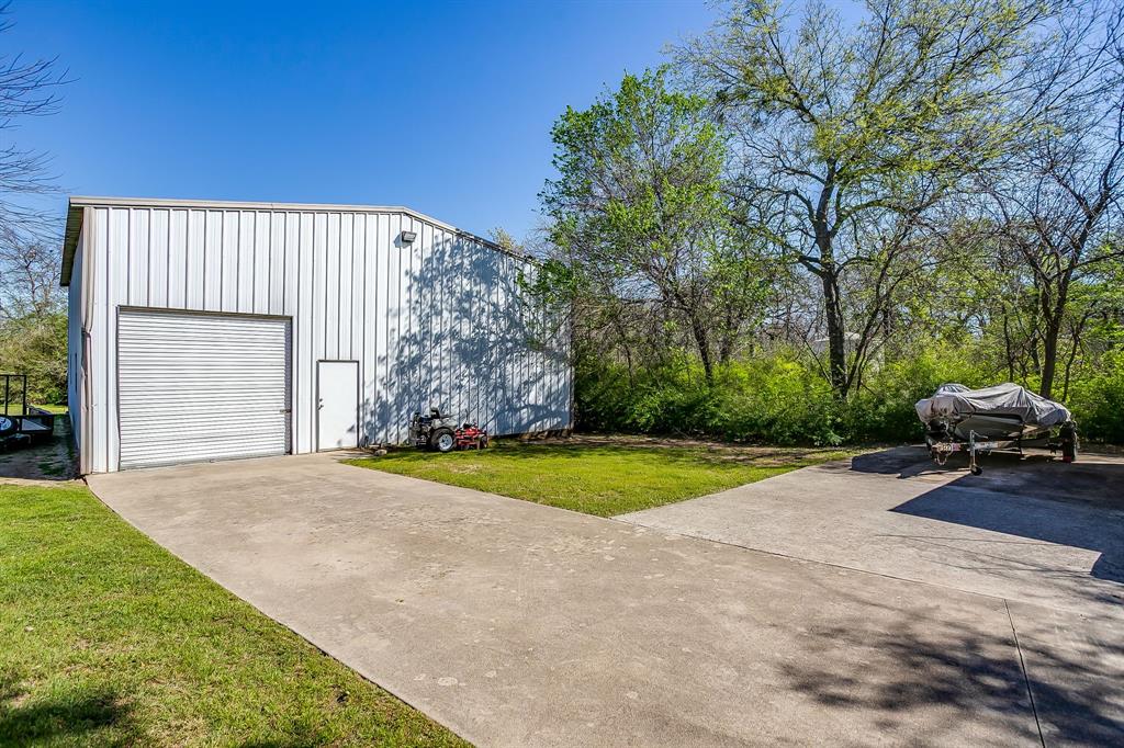 2300 Walter Smith Road Azle, TX 76020 - Photo 36 of 40 a view of backyard of house with car parked and trees in the background