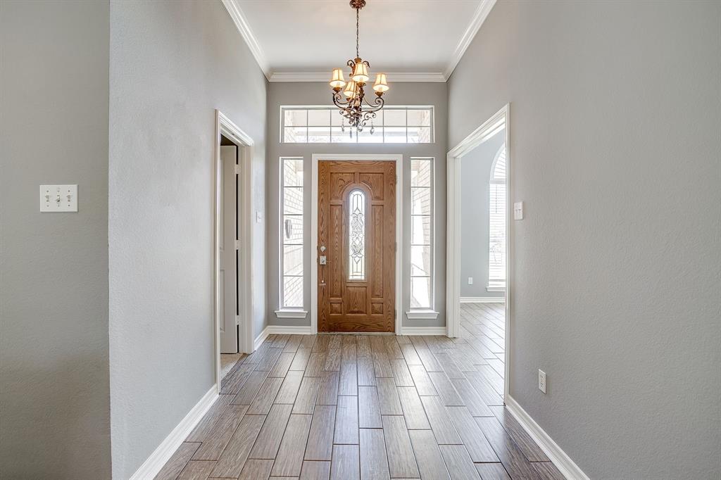 2300 Walter Smith Road Azle, TX 76020 - Photo 5 of 40 a view of a hallway with wooden floor and a chandelier