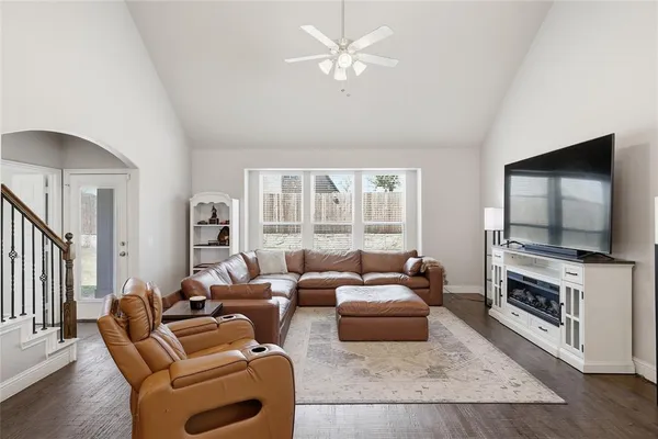 a living room with furniture a flat screen tv and a fireplace