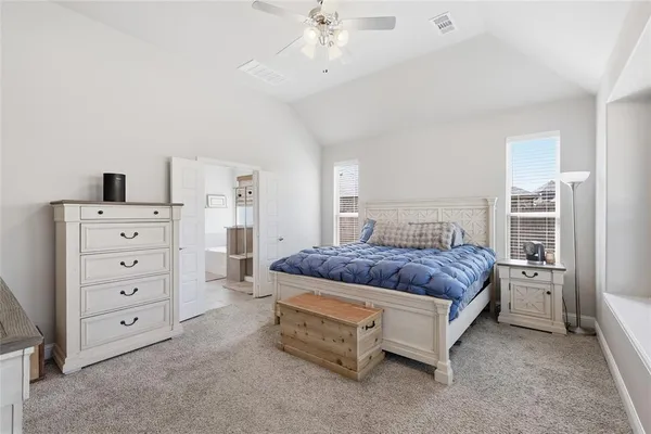 a spacious bedroom with a bed and a cabinets