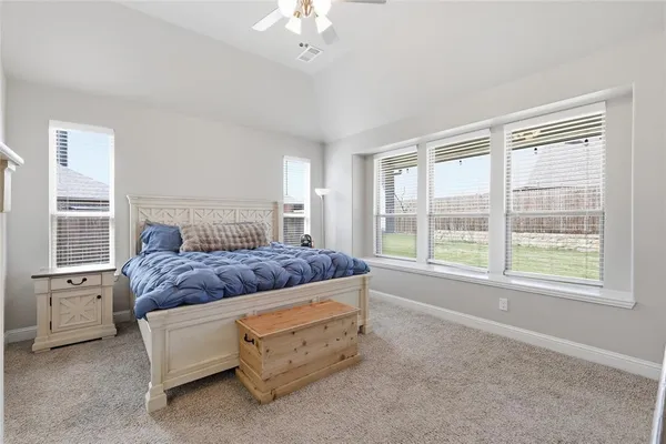 a bedroom with a bed and a large window