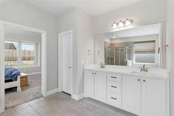 a spacious bathroom with a double vanity sink a mirror and a