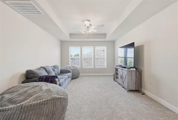 a spacious bedroom with a bed and a chandelier