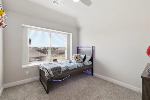 a bed sitting in a bedroom next to a window