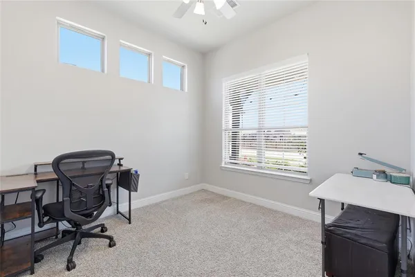 a view of a workspace with furniture and a window