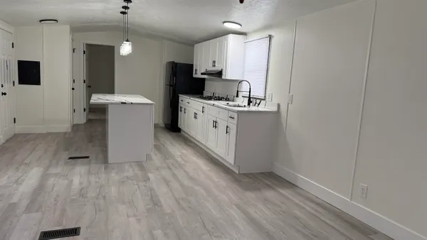 a kitchen with wooden floor and white appliances