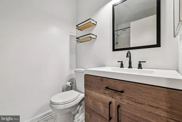 a bathroom with a toilet a sink and mirror