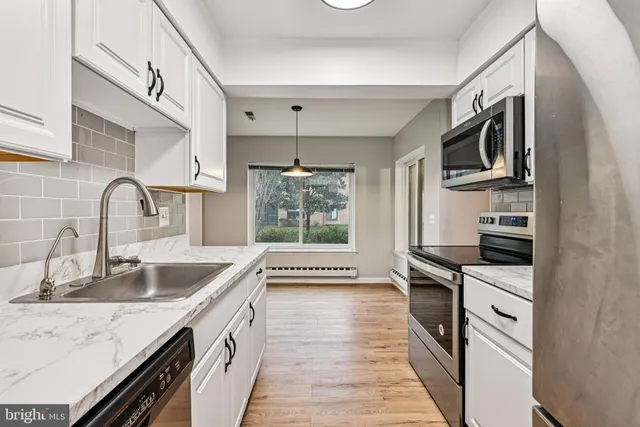 a kitchen with granite countertop a sink and steel appliances
