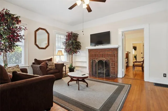 a living room with furniture a fireplace and a flat screen tv