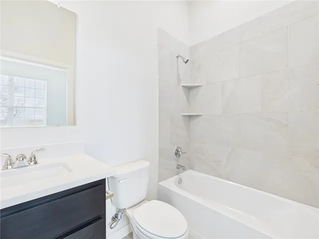 a bathroom with a sink toilet vanity and bathtub