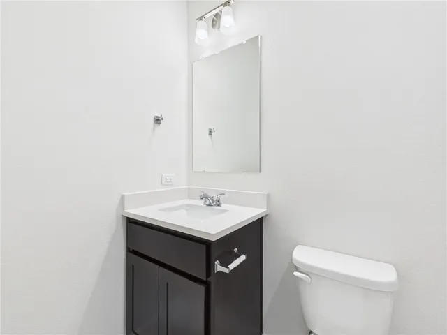 a bathroom with a sink a toilet and mirror