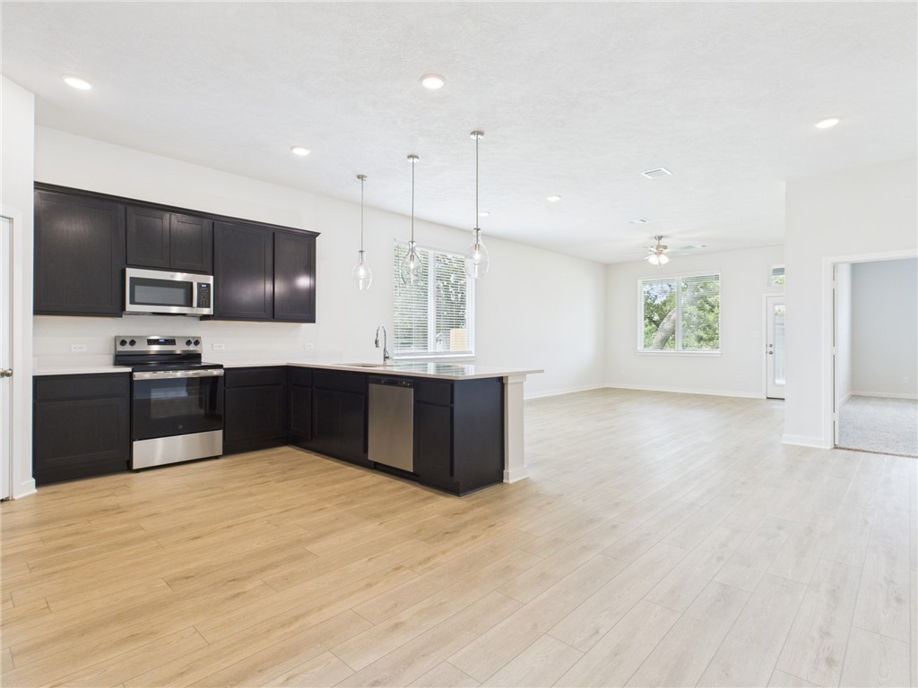 1932 Viva Road Bryan, TX 77807 - Photo 7 of 20 a large kitchen with kitchen island granite countertop a sink a counter top space appliances and cabinets
