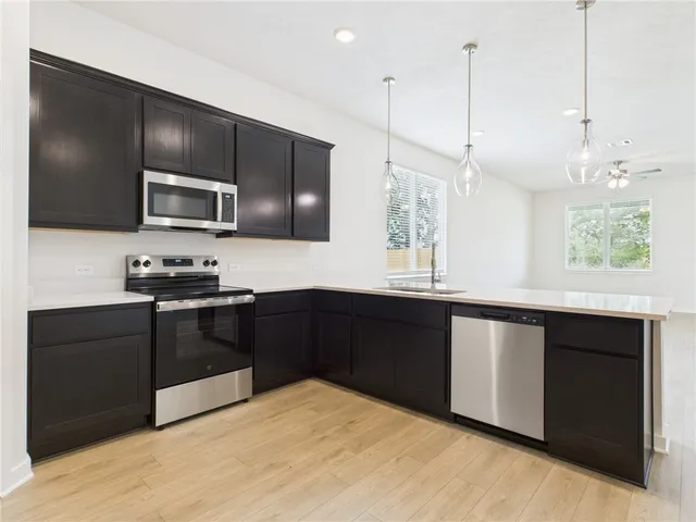 a kitchen with granite countertop stainless steel appliances and sink