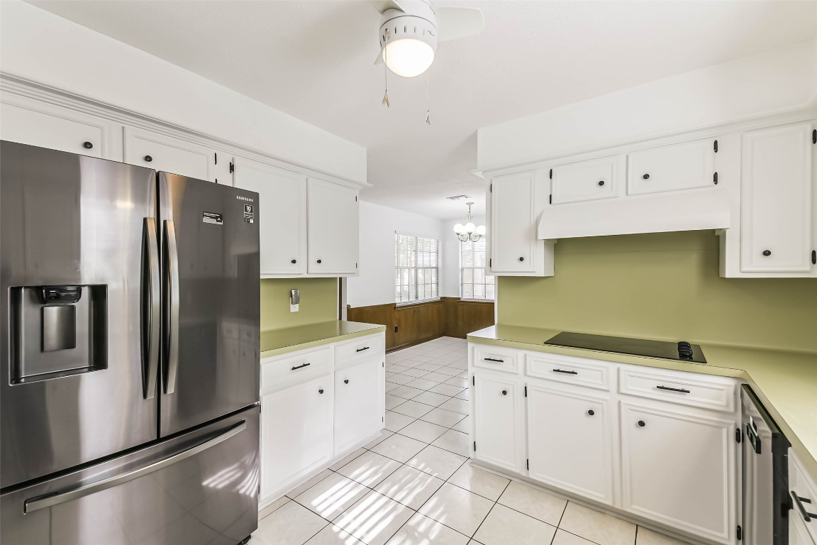 6915 Chancellor Drive Spring, TX 77379 - Photo 12 of 37 a kitchen with stainless steel appliances a refrigerator sink and cabinets