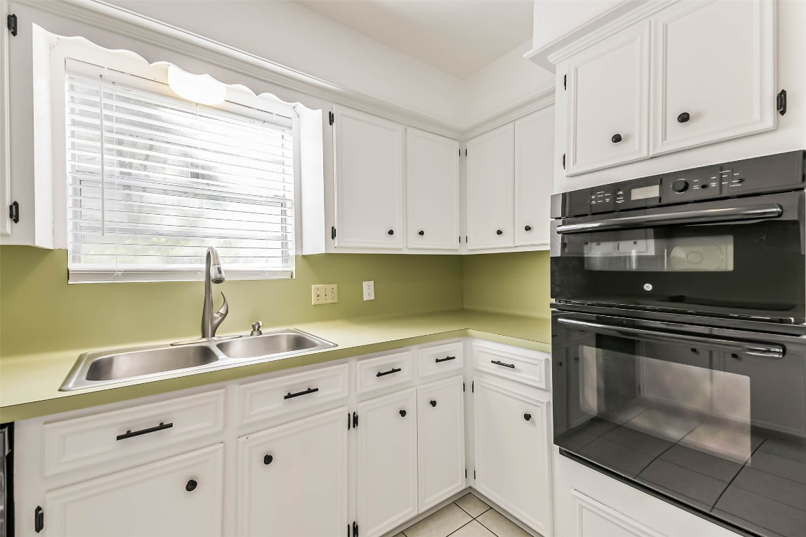 6915 Chancellor Drive Spring, TX 77379 - Photo 14 of 37 a kitchen with granite countertop white cabinets and a stove