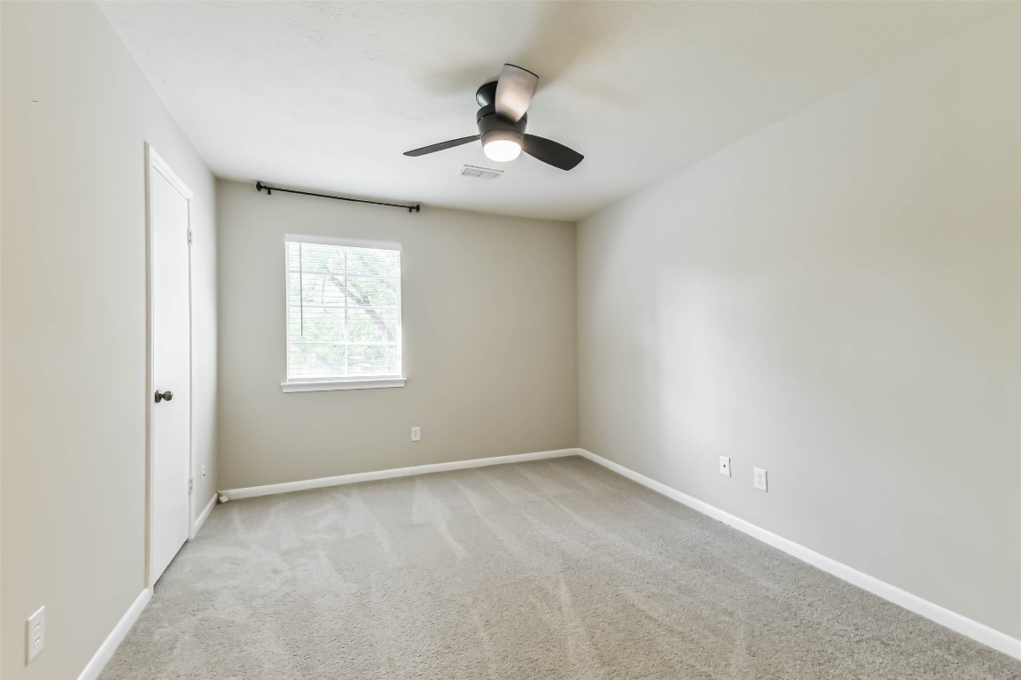 6915 Chancellor Drive Spring, TX 77379 - Photo 25 of 37 an empty room with ceiling fan and windows