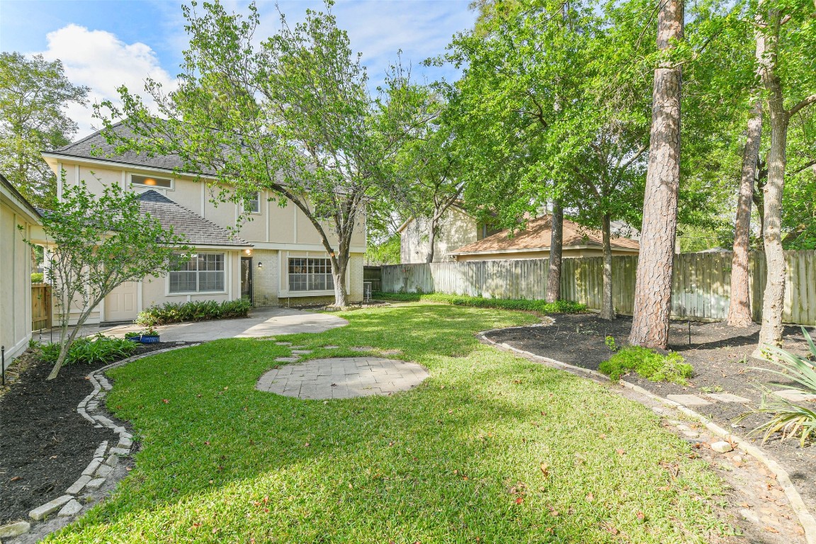 6915 Chancellor Drive Spring, TX 77379 - Photo 34 of 37 a view of a backyard with table and chairs and a large tree