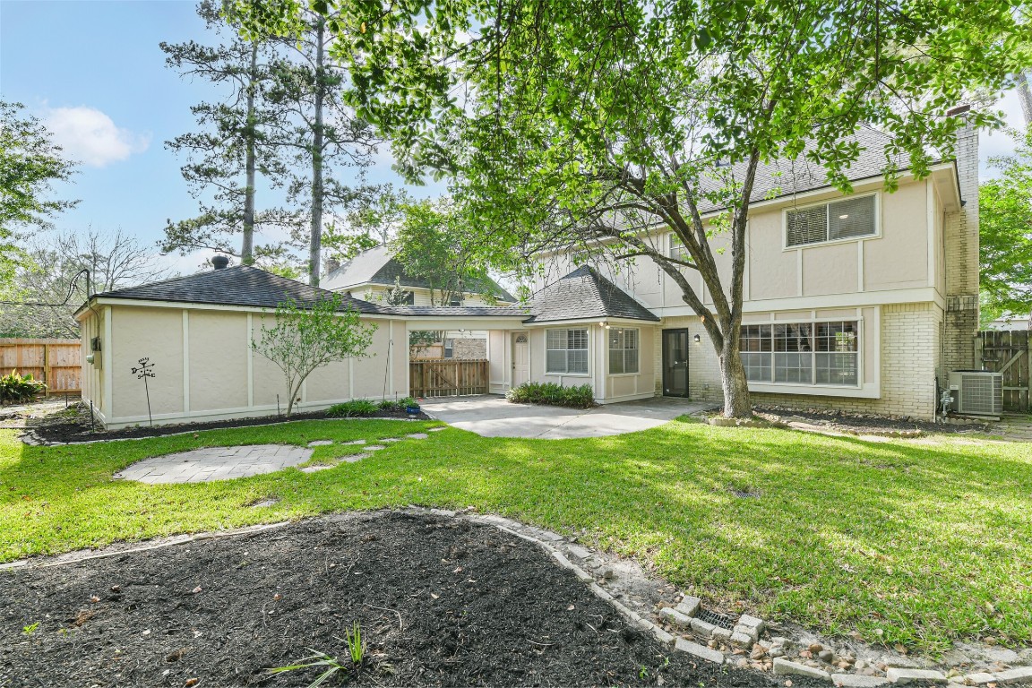 6915 Chancellor Drive Spring, TX 77379 - Photo 35 of 37 a front view of a house with a garden and yard