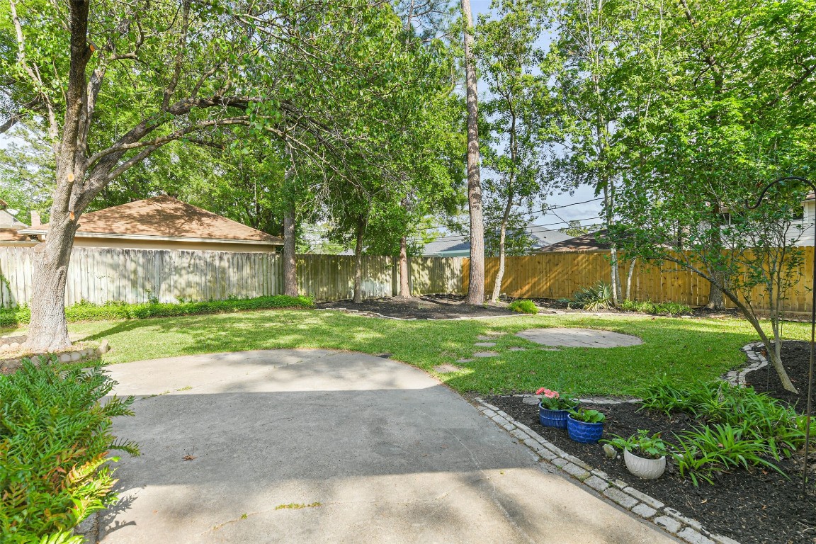 6915 Chancellor Drive Spring, TX 77379 - Photo 36 of 37 a view of a white house next to a yard with big trees
