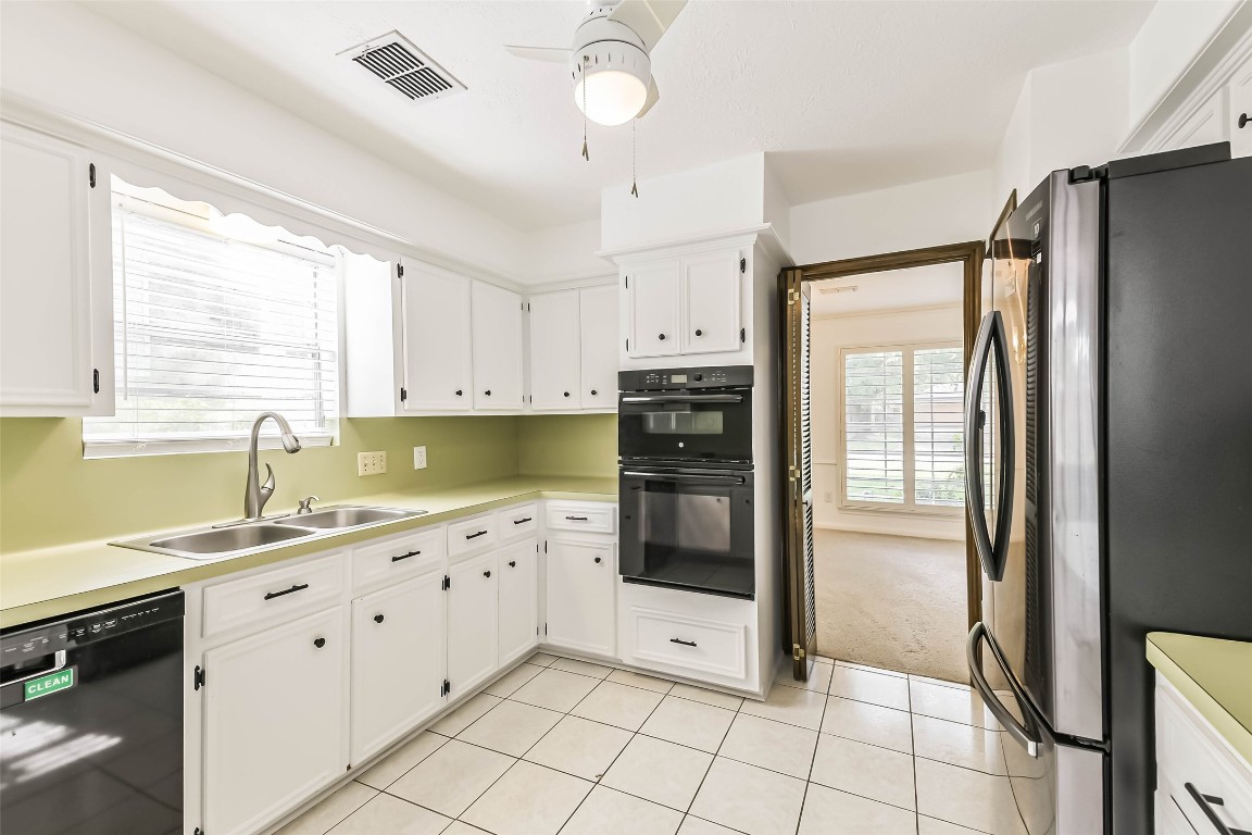 6915 Chancellor Drive Spring, TX 77379 - Photo 10 of 37 a kitchen with granite countertop a refrigerator and a sink