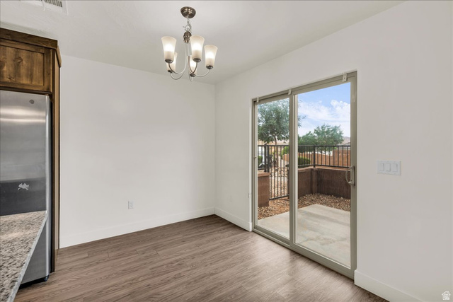 5875 Challenger Way St. George, UT 84790 - Photo 7 of 18 Dining area featuring wood-finish flooring, a four-light chandelier, and white baseboards